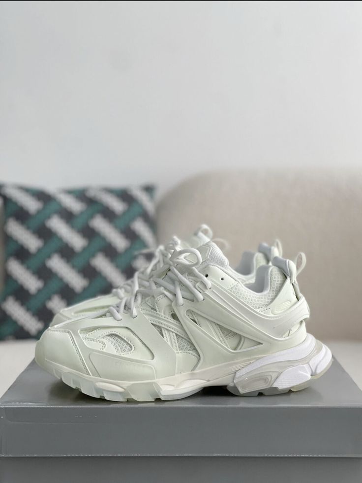 Embrace a futuristic aesthetic with these Track-inspired sneakers, capturing the essence of Balenciaga's iconic design. The clean, all-white colorway creates a minimalist yet bold statement. The multi-layered upper, crafted with a mix of mesh and synthetic materials, provides a dynamic look and breathable comfort. The chunky sole adds a modern edge, while subtle Balenciaga branding details complete the look. Balenciaga Track 2, Shoes 2021, White Platform Sneakers, Platform Trainers, All Black Shoes, Sport Shoes Fashion, Women Platform Shoes, Balenciaga Track, Dad Shoes