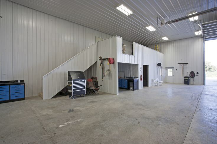 an empty garage with stairs and workbench in the center, on concrete flooring