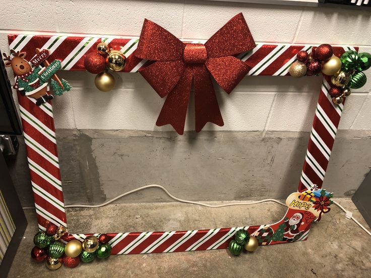 a decorated christmas frame with ornaments and bows on the front, along with other holiday decorations