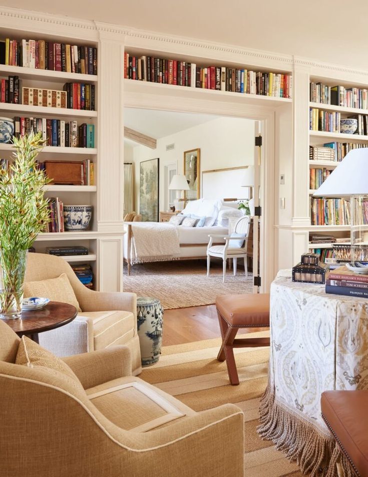 a living room filled with lots of furniture and bookshelves covered in bookcases