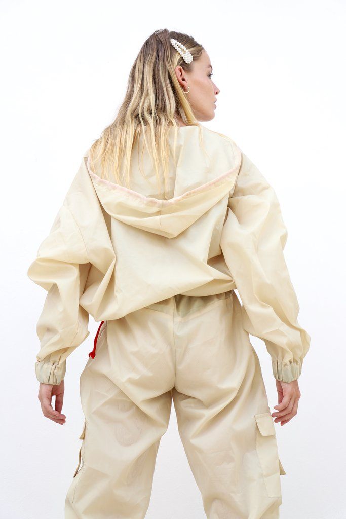 a woman in white is standing with her back turned to the camera and wearing an off - white outfit