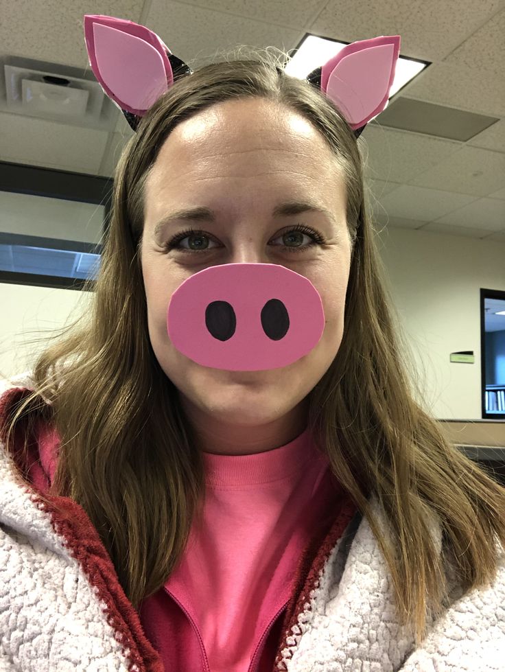 a woman wearing a pig mask in an office