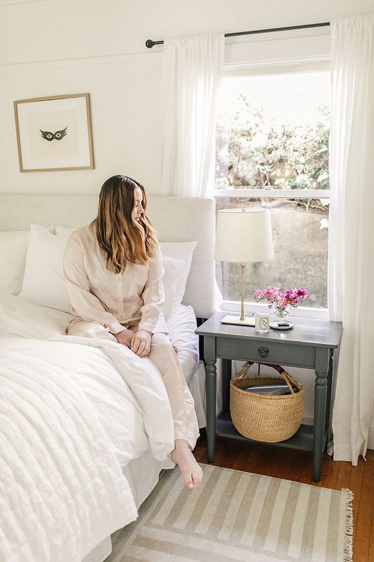 a woman sitting on her bed talking on the phone