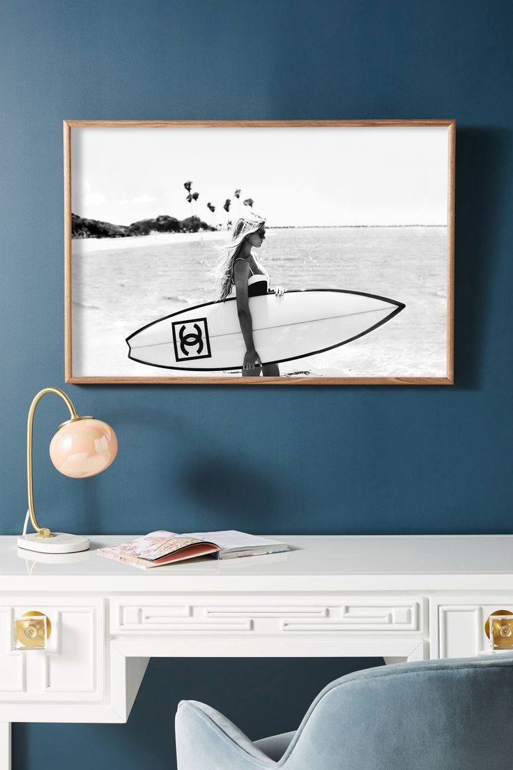 a woman with a surfboard on the beach in black and white framed art print