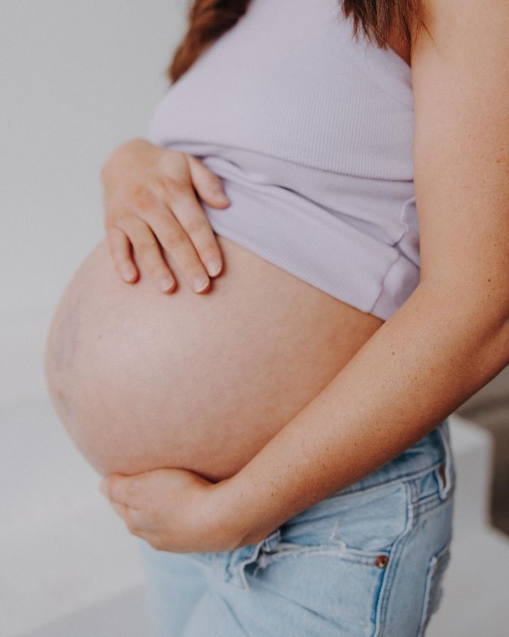 a pregnant woman is holding her stomach