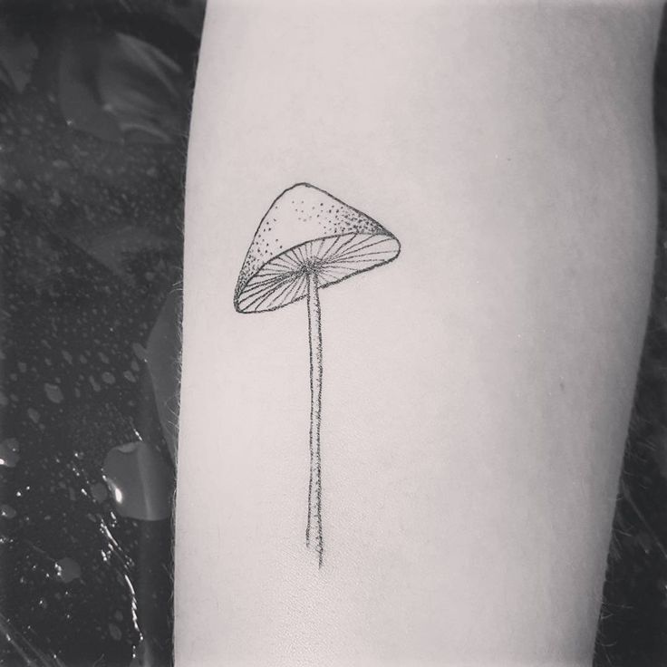 a small mushroom tattoo on the left inner arm and leg, it is black and white