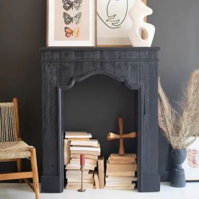 a black fireplace with books and pictures on it