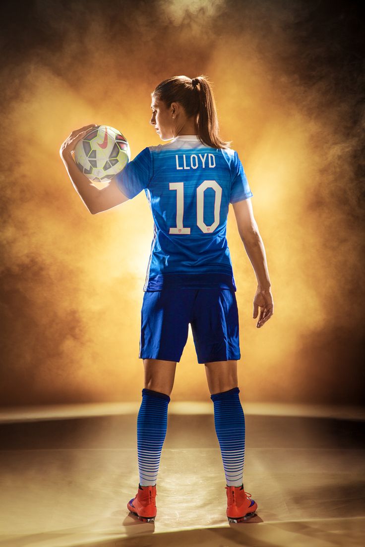 a female soccer player is holding a ball