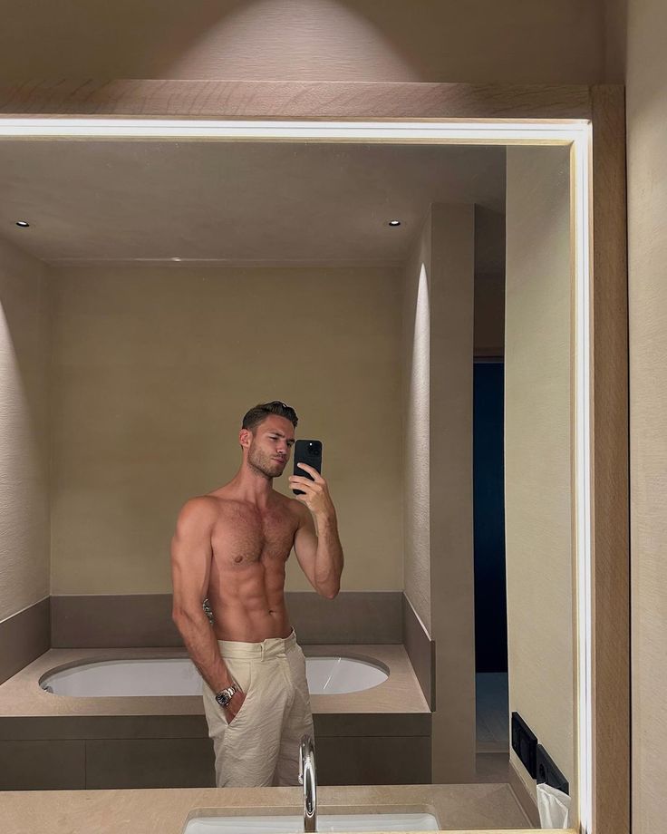 a man taking a selfie in a bathroom mirror with his phone up to his face