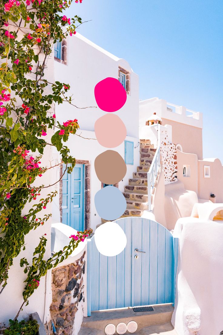 a white house with blue doors and pink flowers