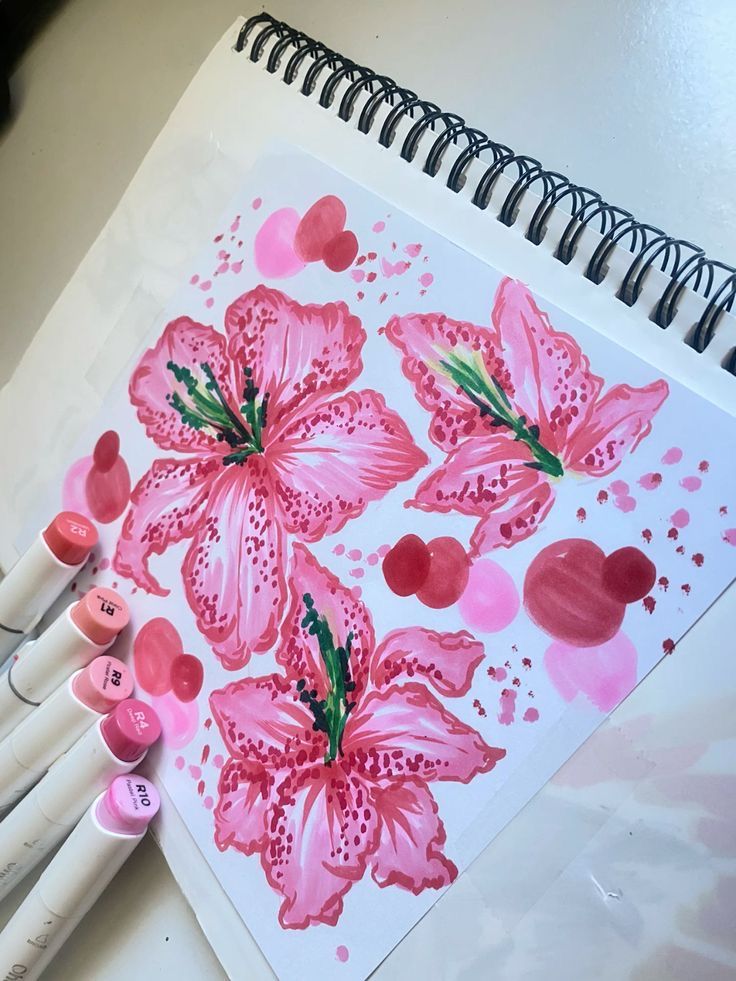 some pink flowers and hearts are on a white sheet of paper next to crayons