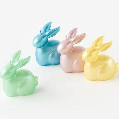 four small plastic rabbits sitting next to each other