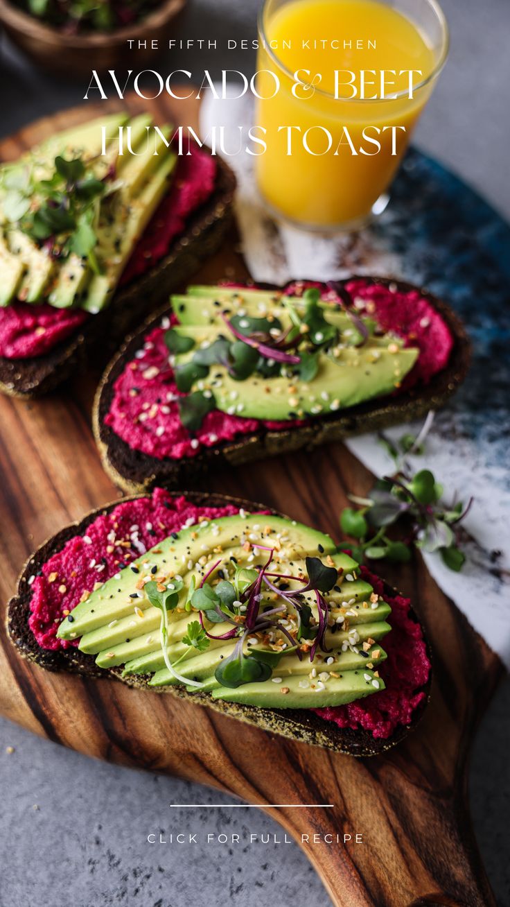 avocado and beet toast on a cutting board with a glass of orange juice