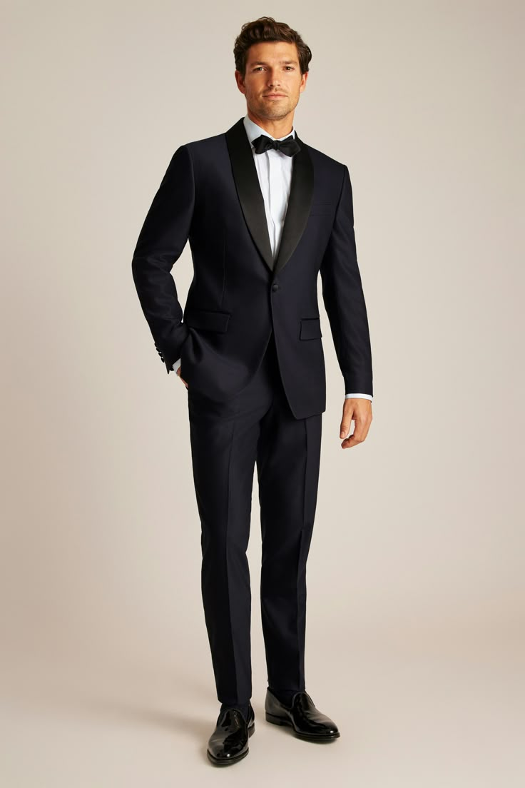 a man in a tuxedo poses for the camera