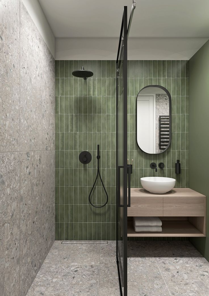 a green tiled bathroom with a shower, sink and stand - up shower head mounted on the wall