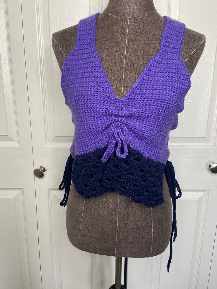 a mannequin wearing a purple and blue crochet top with a bow