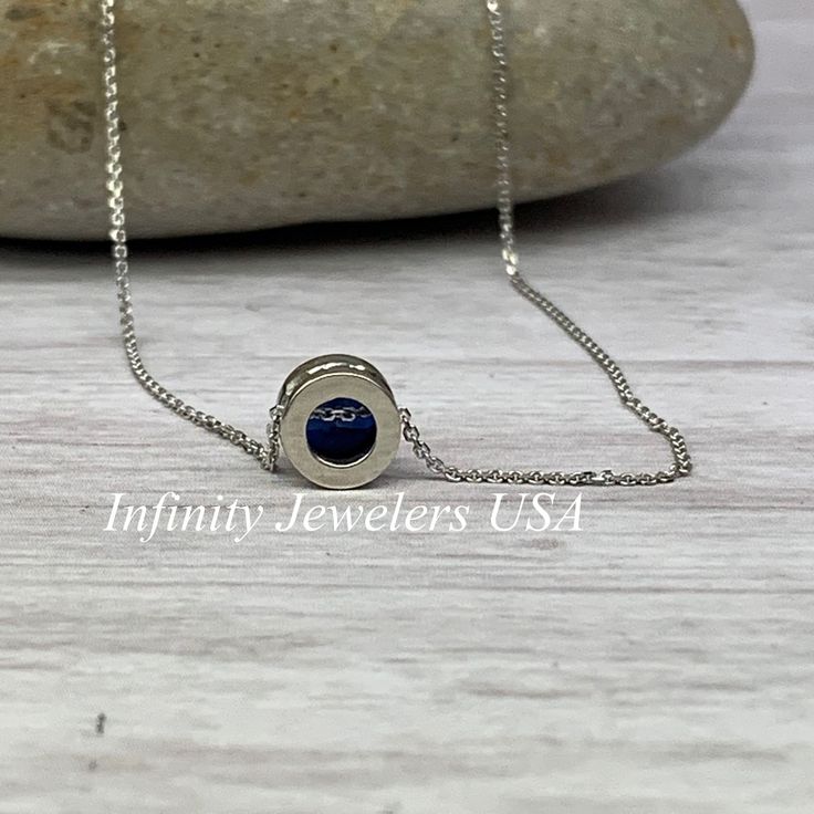 "The pendant pictured is lab created blue sapphire #5871 -Approximate total carat weight: approx. .80ctw diamond equivalent -Center Stone Size: 6mm - approx. .80ct diamond equivalent -Center Stone Shape: round -Gem Type: lab created sapphire -Stone Clarity: VS2 -Stone Color: Blue -Moh's Scale: 9 hardness -Metal Type and Purity: 14k white gold -Setting: bezel set floating necklace -Chain: 18\" delicate 14k gold chain / heavier option with lobster claw available (use dropdown to select) -Country o Sapphire Birthstone Necklace In Lab-created Sapphire, Sapphire Birthstone Necklace With Lab-created Sapphire, Lab-created Sapphire Birthstone Necklace, Sapphire Cubic Zirconia Jewelry With Polished Finish, Polished Sapphire Cubic Zirconia Jewelry, Blue Bezel Setting Fine Jewelry, Sapphire Colored Cubic Zirconia Jewelry With Polished Finish, Polished Sapphire Round Stone Jewelry, Polished Sapphire Jewelry With Round Stone