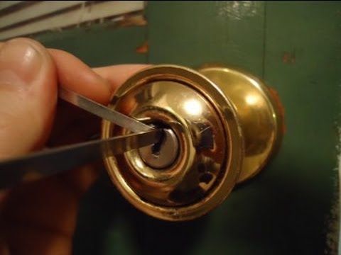 a person holding a pair of scissors near a door knob