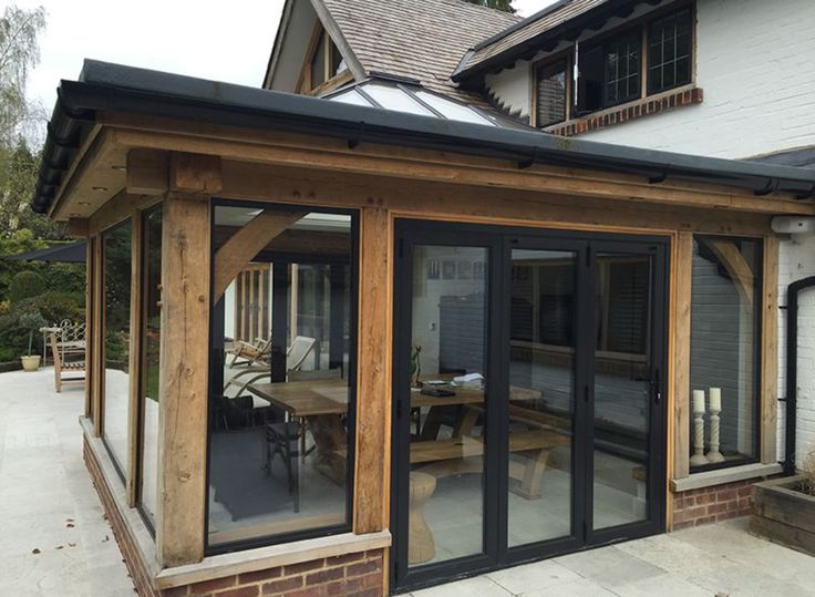 an outdoor patio area with sliding glass doors and wooden furniture on the outside, surrounded by white brick buildings