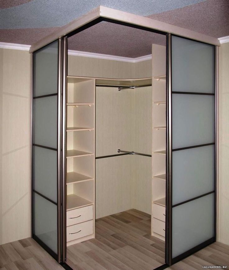 an empty walk in closet with sliding doors and shelves on each side, open to reveal another room