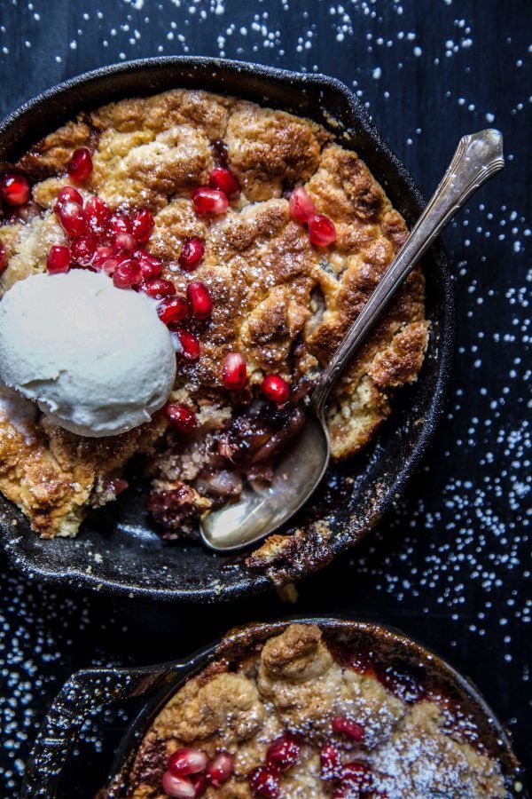 two skillets filled with cranberry cobbler and ice cream on top of them