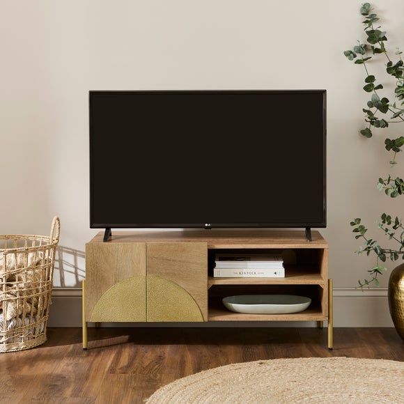 a flat screen tv sitting on top of a wooden entertainment center next to a plant