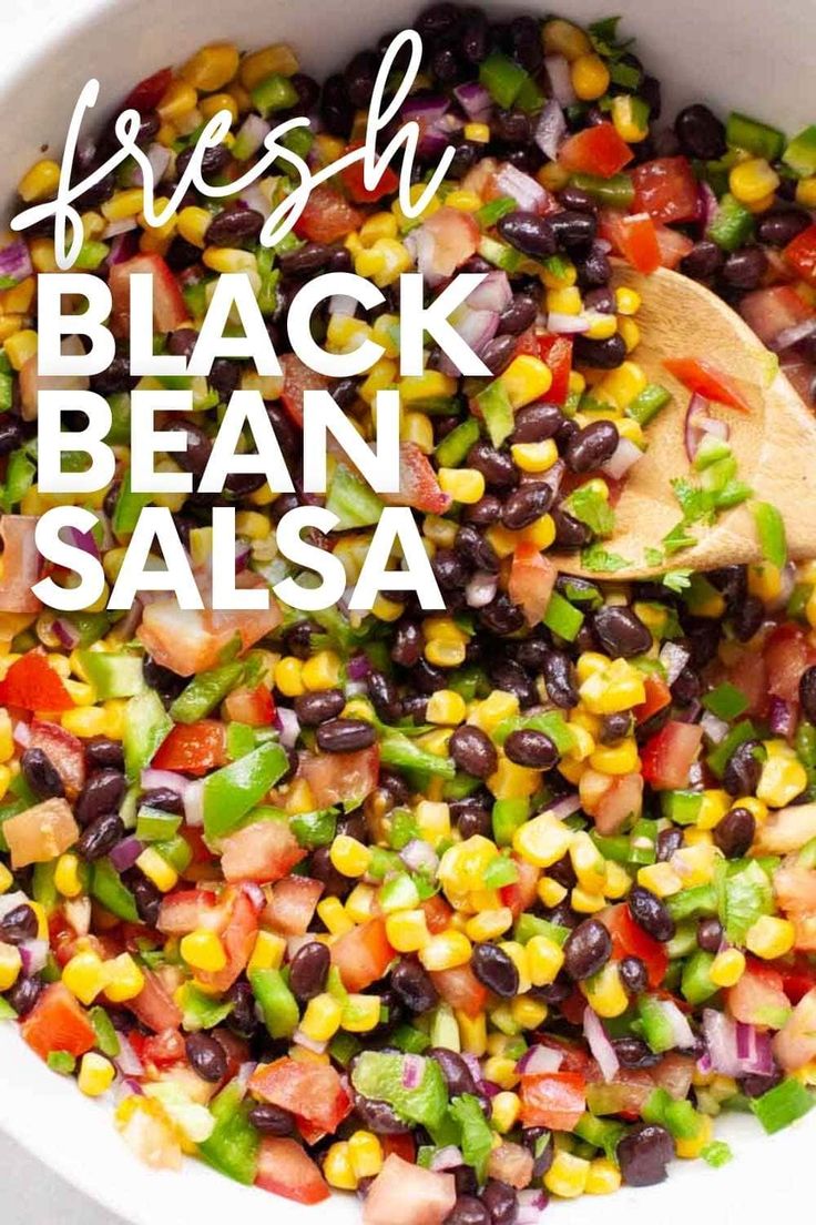 fresh black bean salsa in a white bowl with a wooden spoon and text overlay