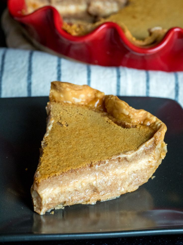 a slice of pumpkin pie on a black plate