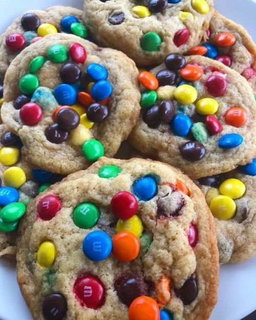 several cookies with m & m and m's on them sitting on a plate