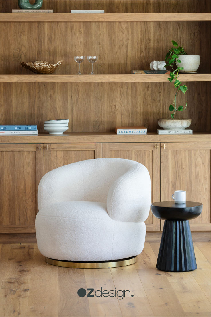 a white chair sitting on top of a hard wood floor next to a wooden shelf