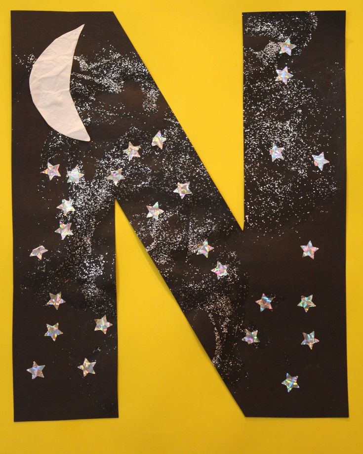 the letter n is made out of paper with stars and a moon on it's side