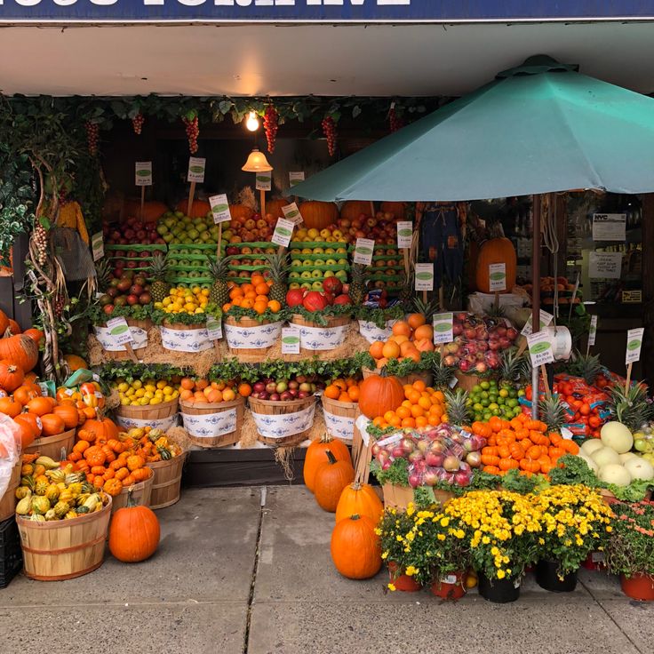 a farmers market with lots of fresh fruits and veggies on display for sale