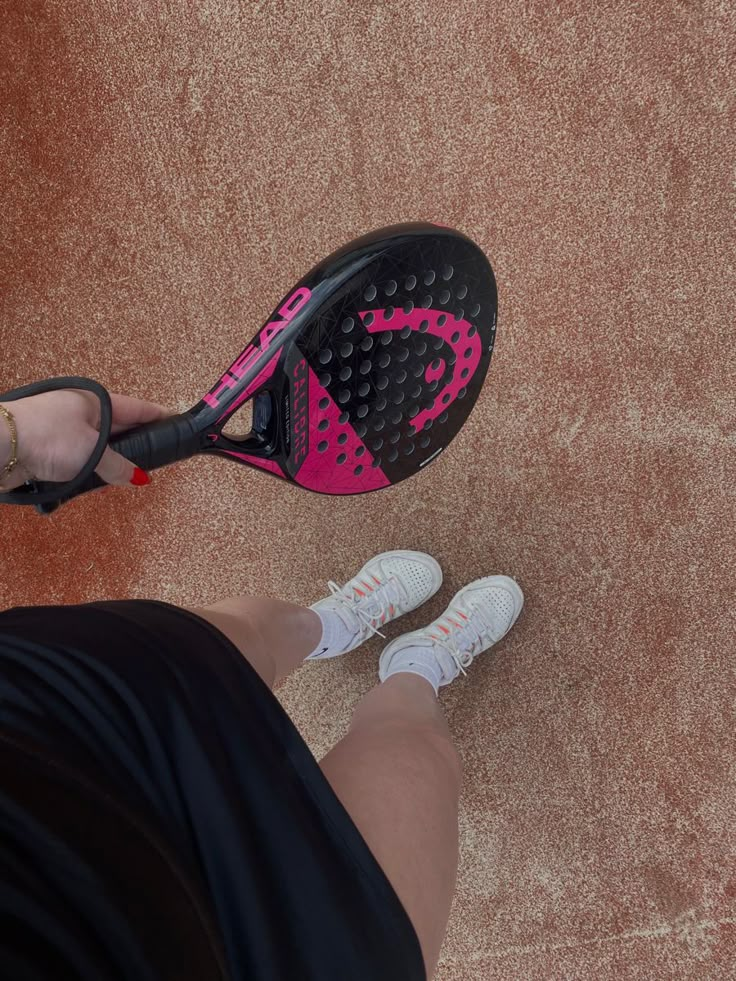 a person holding a tennis racquet on top of a court with shoes on