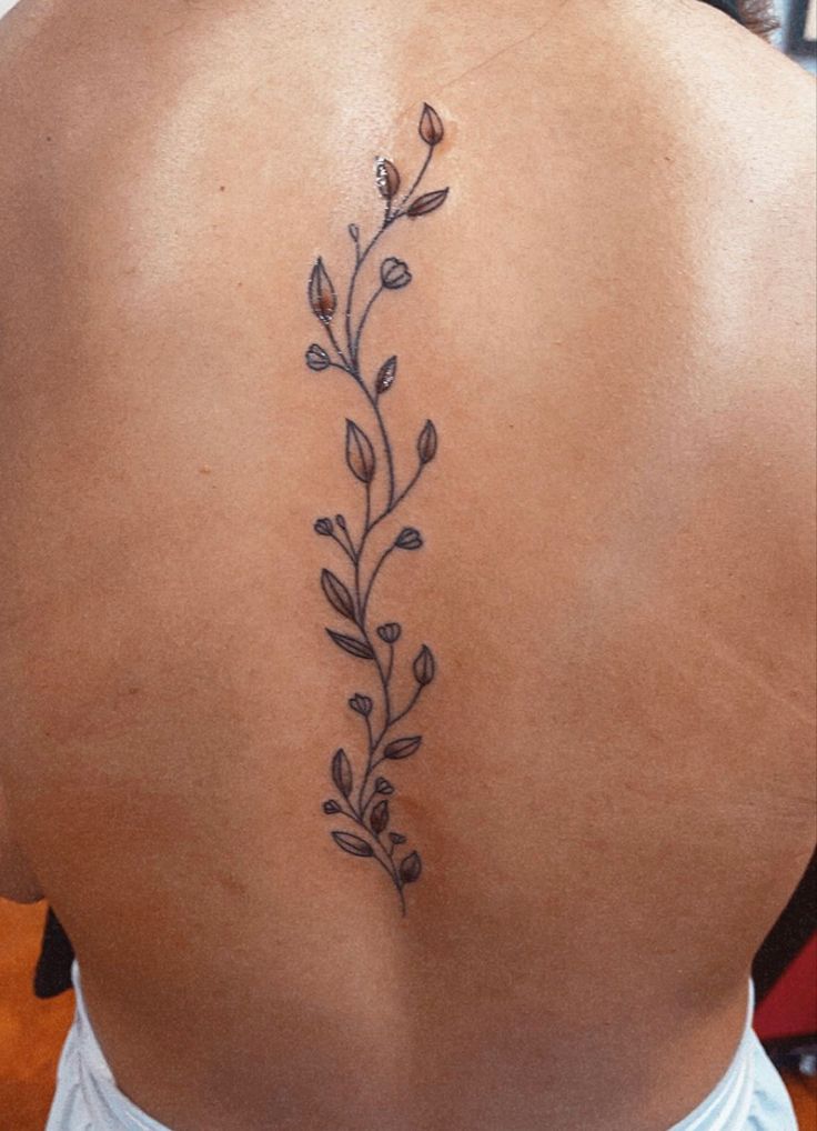 the back of a woman's neck with flowers on it