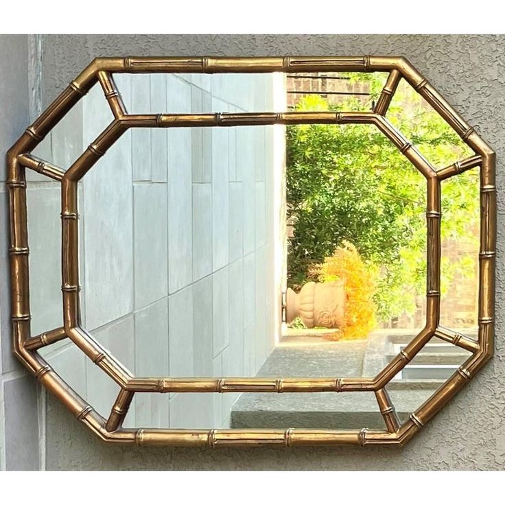 a mirror that is sitting on the side of a wall next to a planter