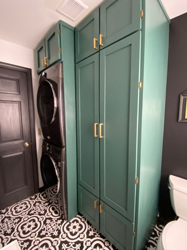 a washer and dryer in a bathroom with black and white floor tiles on the floor