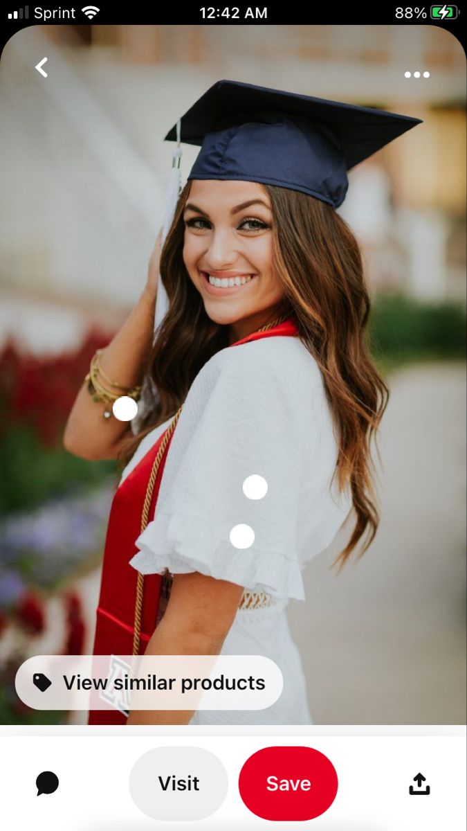 a woman wearing a graduation cap and gown posing for the camera with her hand on her head