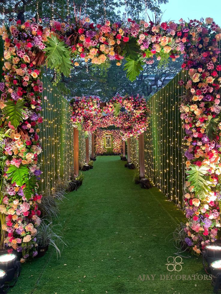 an outdoor walkway decorated with flowers and greenery