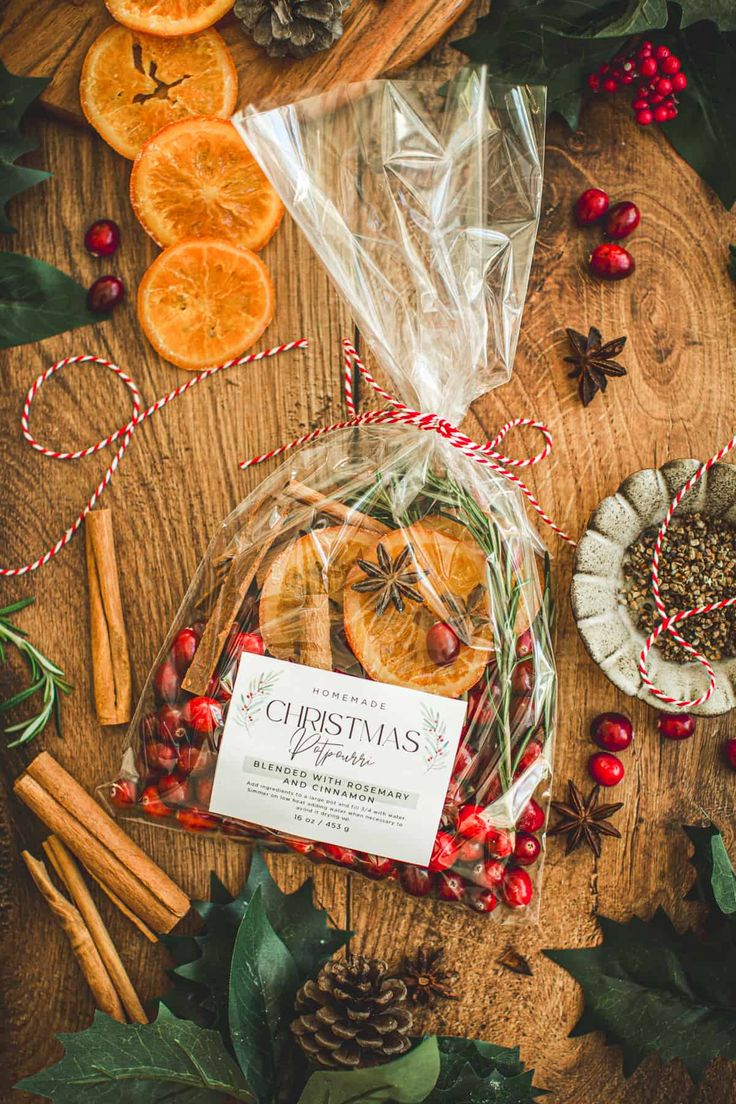 an assortment of dried oranges and cinnamon sticks on a wooden table surrounded by christmas decorations