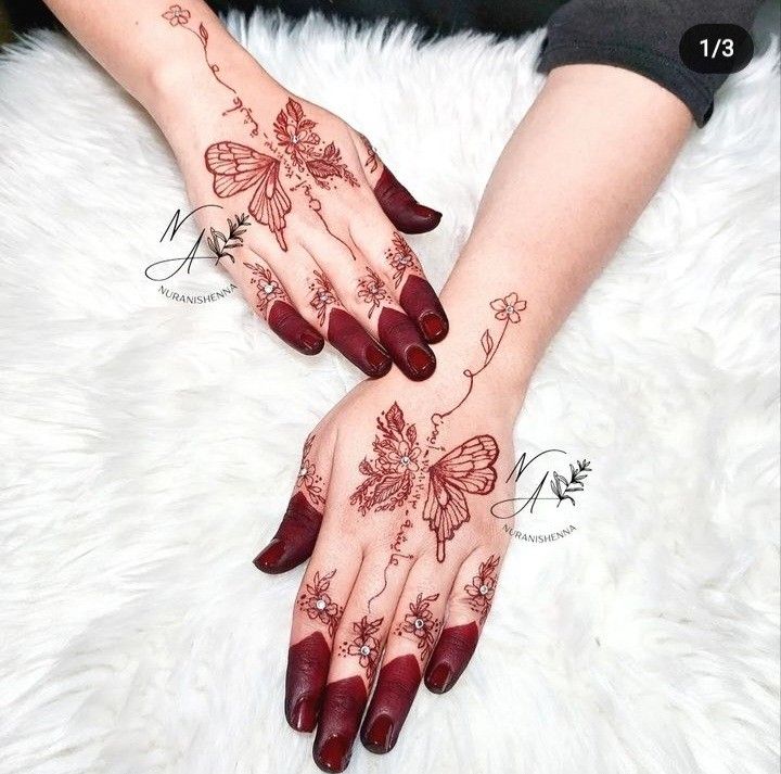 a woman's hands with hendix and flowers painted on their palms