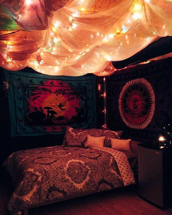 a bed with lights on the ceiling above it and a wall hanging in front of it