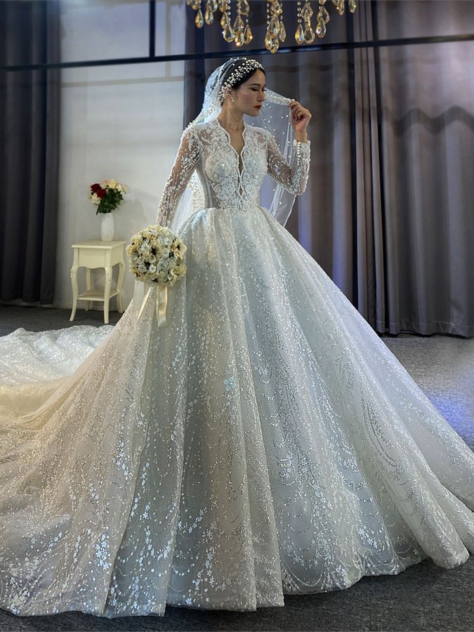 a woman in a white wedding dress standing on a stage wearing a tiara and veil