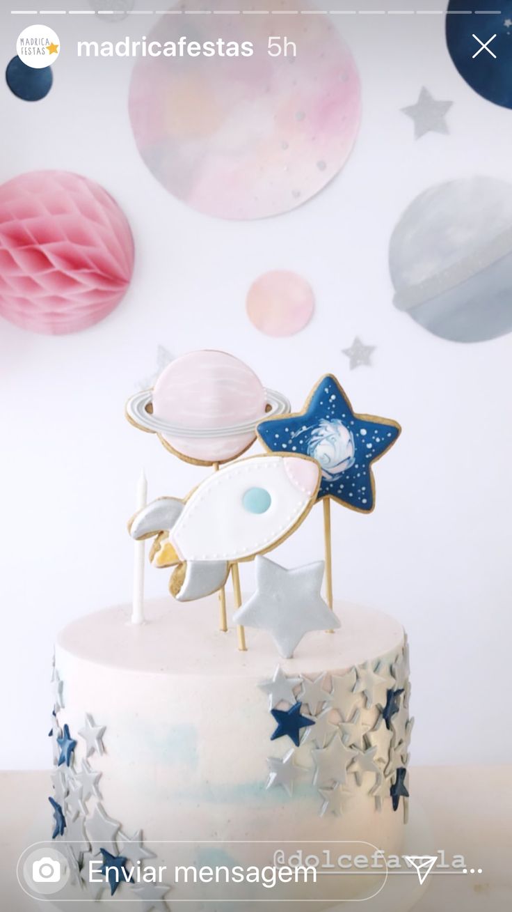 there is a cake with stars and planets on the top, along with other decorations