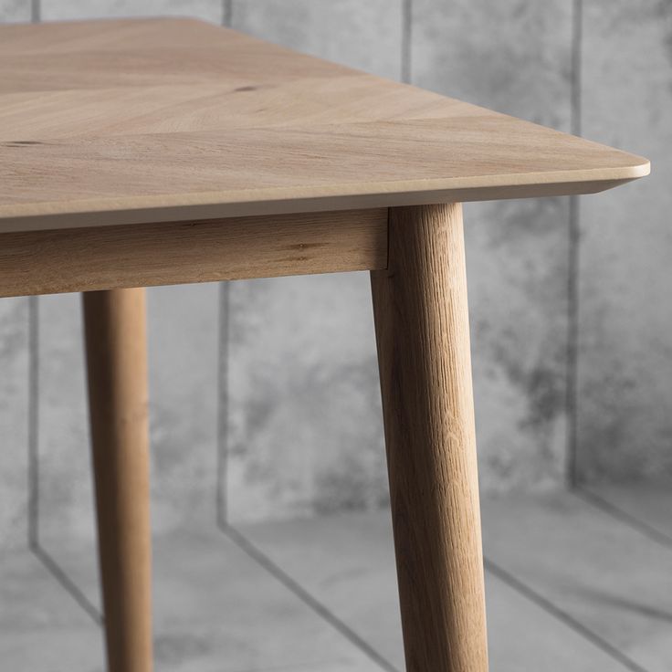 a wooden table sitting on top of a tile floor next to a white tiled wall