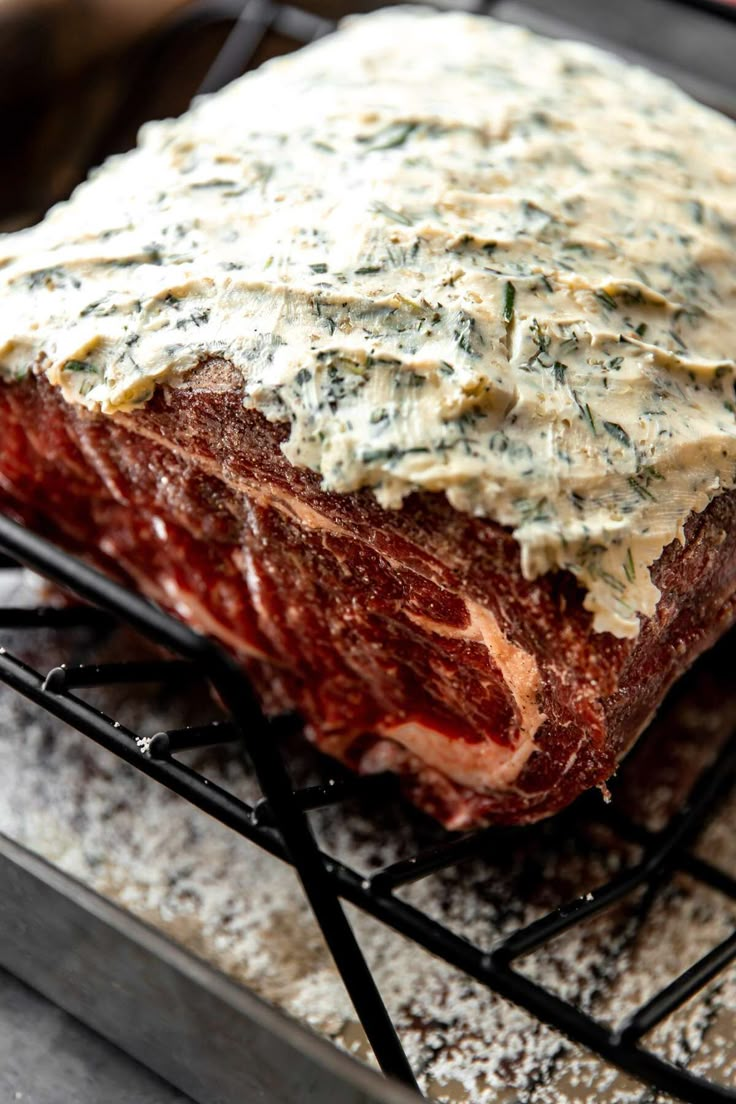 a large piece of meat with sauce on it sitting on top of a wire rack