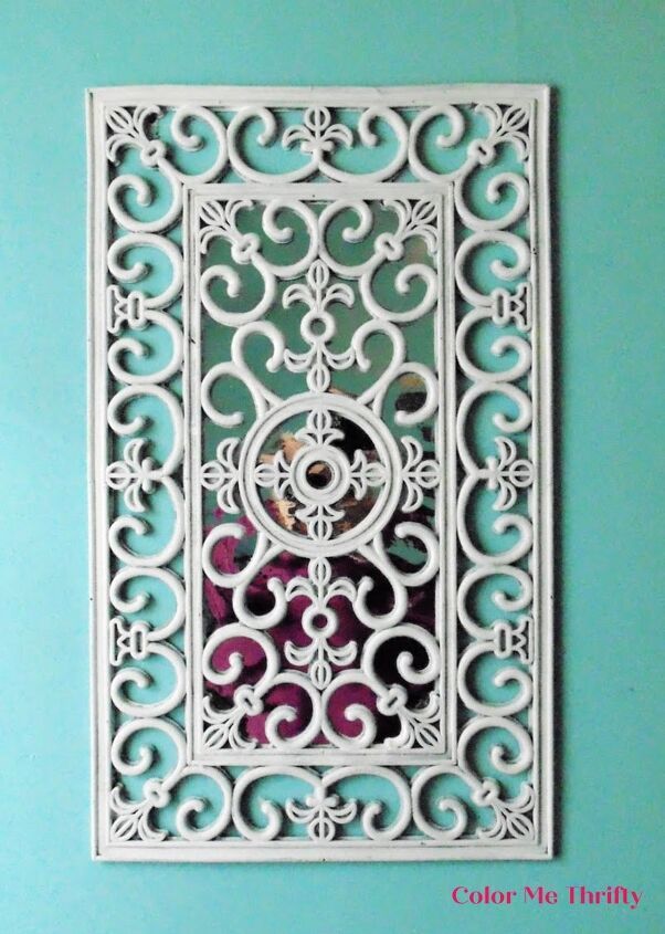 a white metal wall hanging on a blue wall