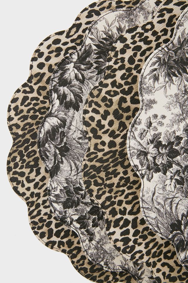 three leopard print plates with black and white designs on the top one has an animal print design