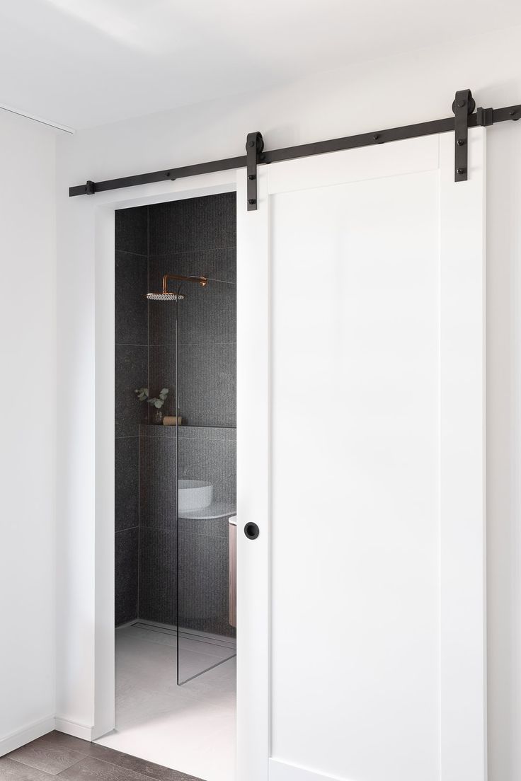 an open sliding door in a white bathroom