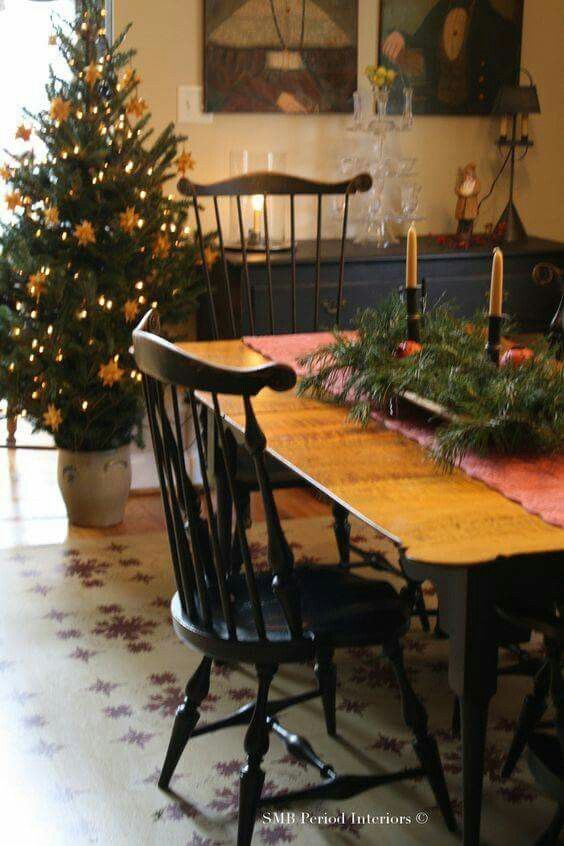 a dining room table with two chairs and a christmas tree