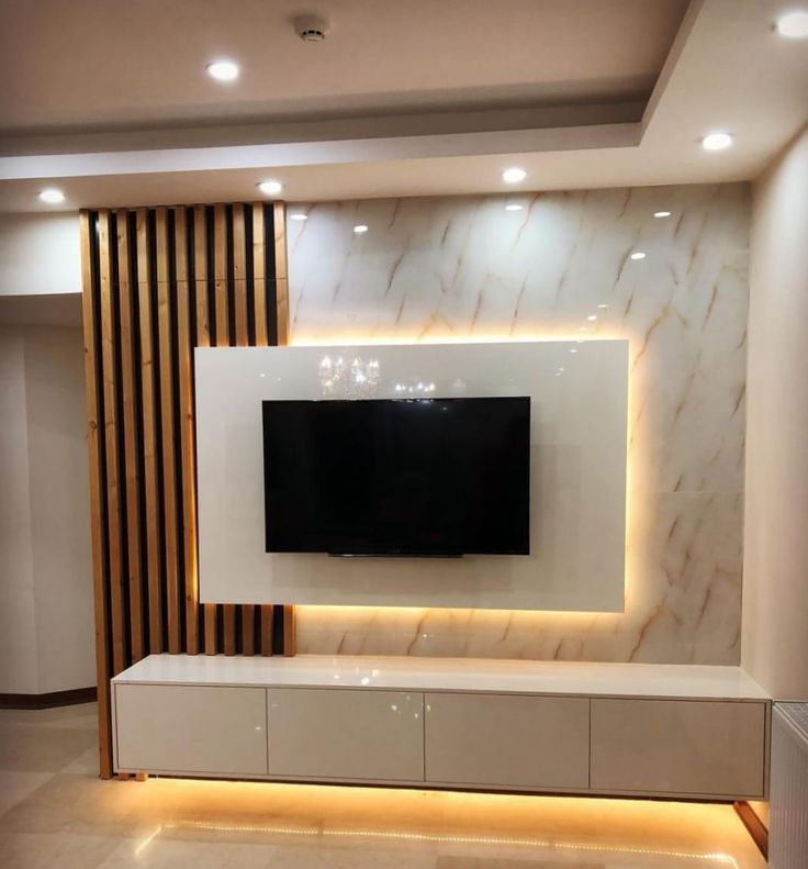 a large television mounted on the wall in a room with white walls and marble flooring